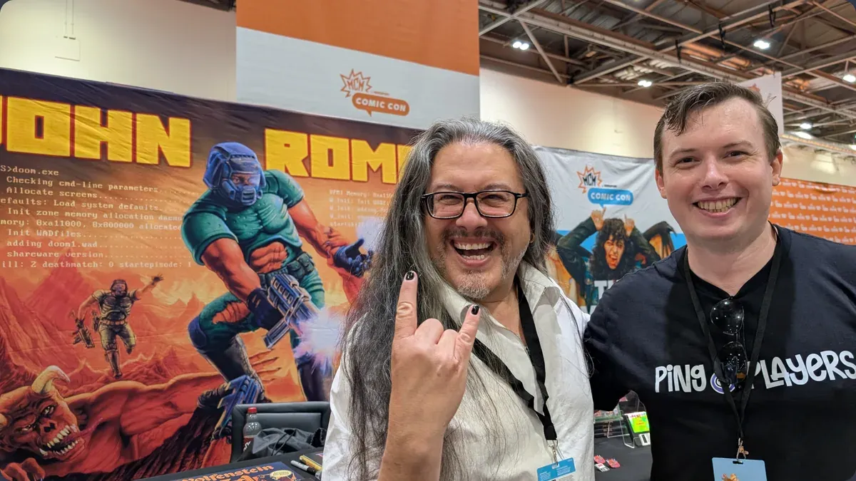 A team member with a guest in front of the Doom art at MCM Comic Con